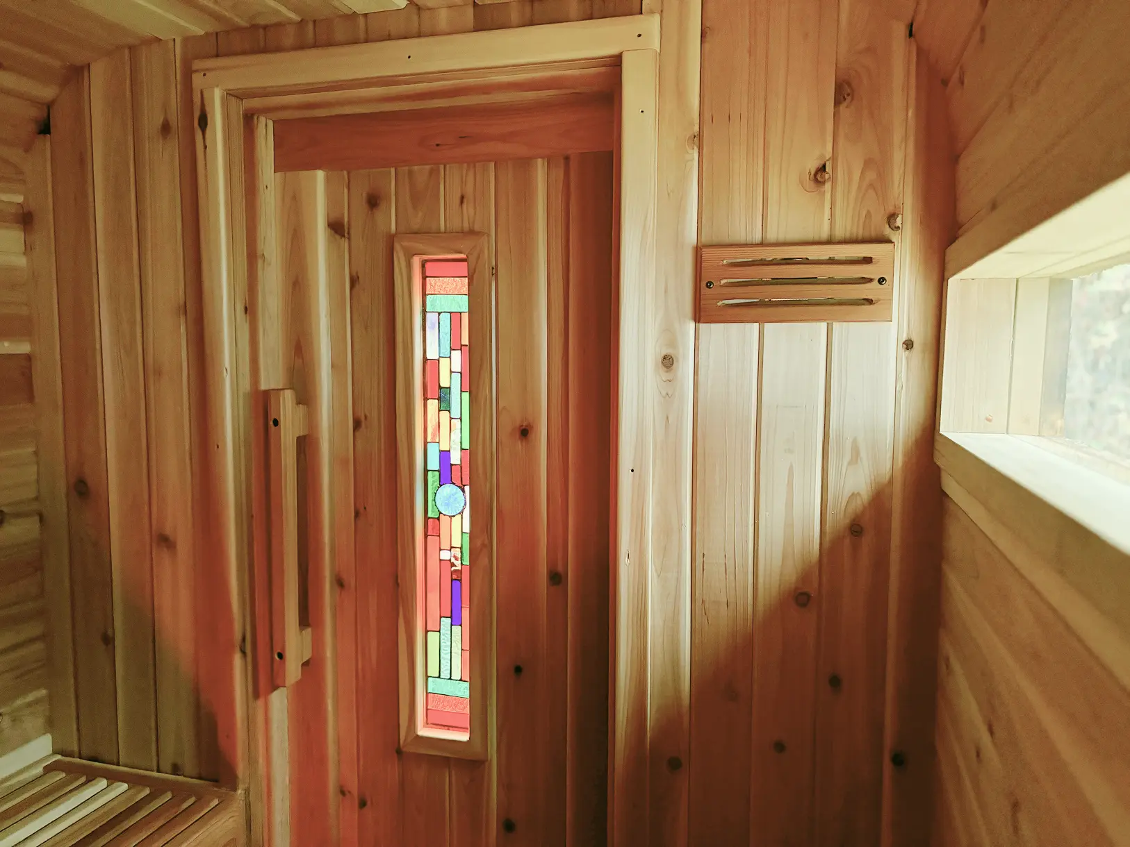 Handcrafted stained-glass door inside the rental sauna